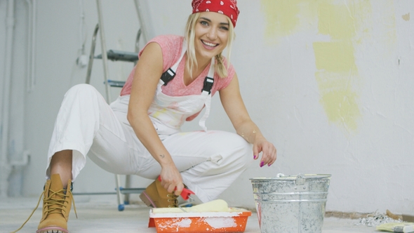 Smiling Female Dipping Paint Roller in Tray alt