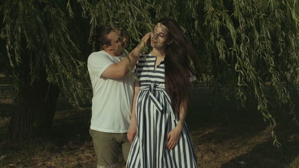 Loving Parents Expecting Baby Embracing in Park alt