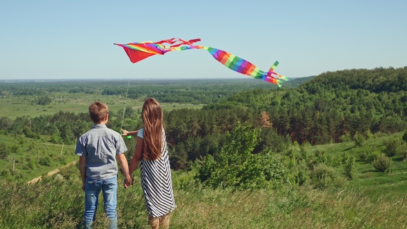 Little Boy and Girl Holding a Flying Kite alt