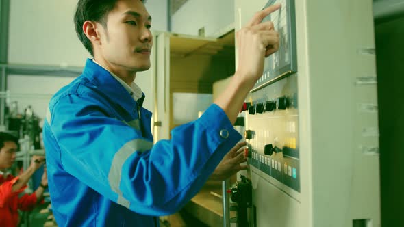 Male Asian engineer professional hand control machine screen  in the factory