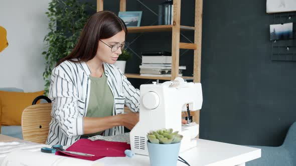 Portrait of Creative Girl Sewing Garment with Electric Machine Enjoying Hobby at Home alt