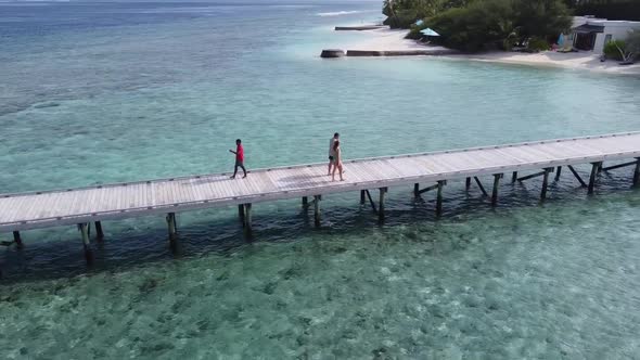 A Man and a Woman Couple Walking on Wooden Decking Bridge Holding Hands