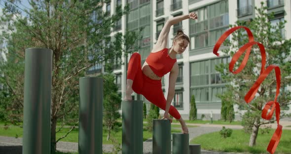 Young Woman in Red Performs Callisthenics with Ribbon in the Libing Apartment Yard, Gymnast Does