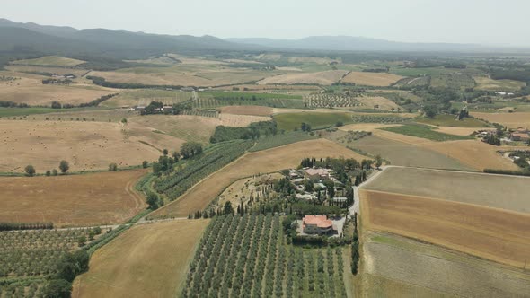 Aerial images of Tuscany in Italy cultivated fields summer, Flight over an agricultural farm with ne alt