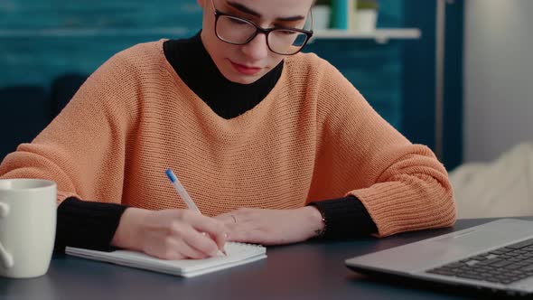 Portrait of Woman Smiling and Writing Course Report on Notebook alt
