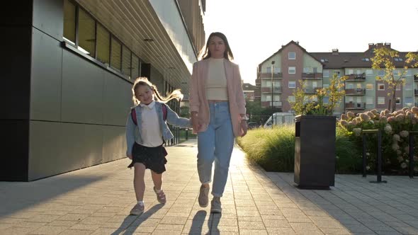 Young Woman Leads Her Daughter 67 Years Old to School By the Hand alt