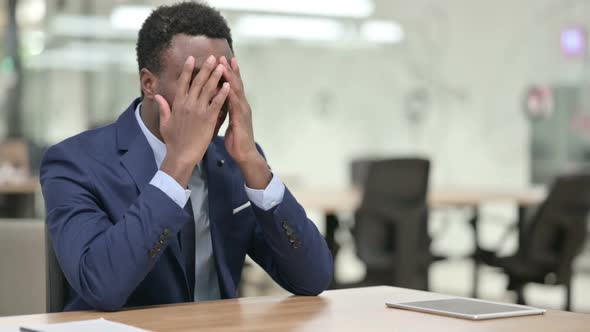 Upset African Businessman Worried While Sitting in Modern Office alt