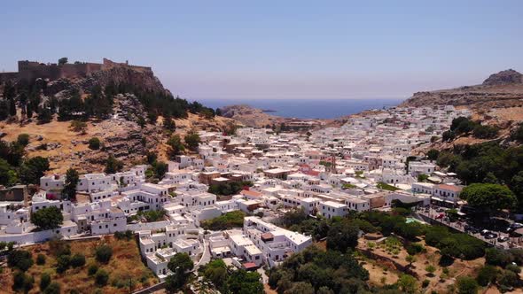 Greek Whitewashed Village Of Lindos In The Island of Rhodes, Greece. Aerial Tilt-up alt