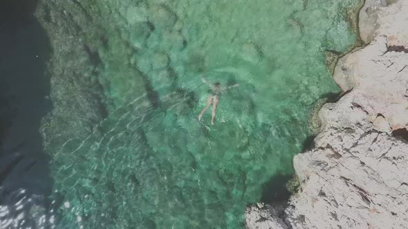 Woman dives into water. Aerial view of Katholiko Gorge in Crete. Relax concept alt