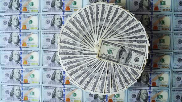 Top view of money rotation. Rich background of american one hundred dollar bills.  alt