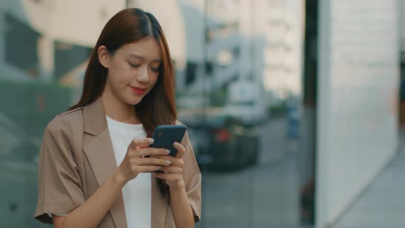 Asian Businesswoman using a mobile phone. Asian successful businessperson looking at smartphone