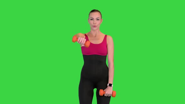 Woman Lifting Dumbbells Working on Her Shoulders on a Green Screen Chroma Key alt