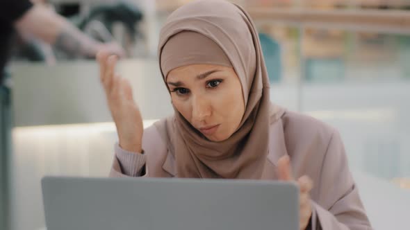 Young Arab Sorrowful Woman in Hijab Reading Message on Laptop Gets Bad News Denied Bank Loan Job alt