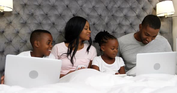 Family using electronic devices in bedroom 4k alt