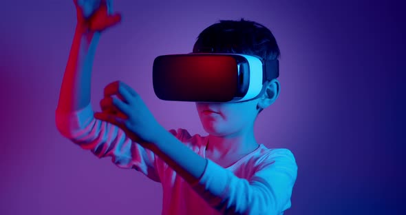 Teenage Boy Using Virtual Reality Headset Against Purple and Blue Background