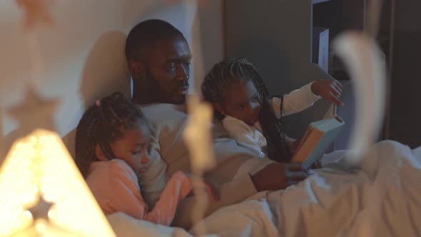 Dad and Daughters Reading Book to Sleep alt