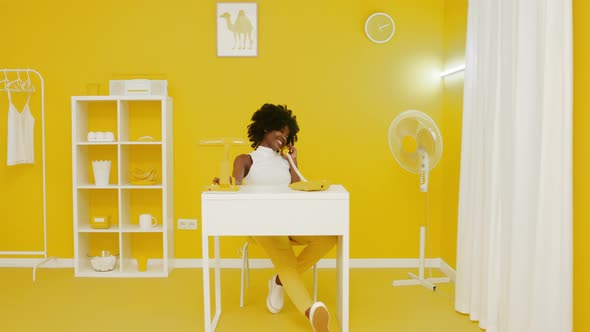 Black Woman Is Talking On Phone In Creative Office alt
