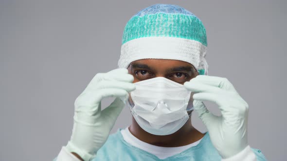 Tired Surgeon Taking Facial Mask and Goggles Off alt