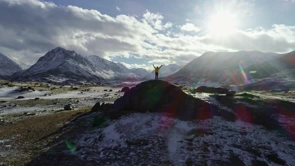 Mountaineer Reaches the Top of a Snowy Mountain in a Sunny Winter Day. alt