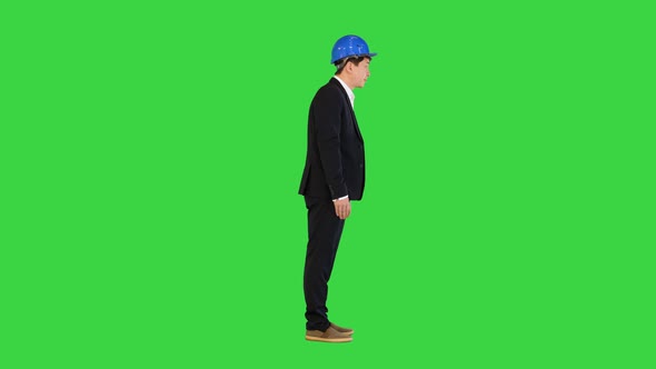 Bowing Young Asian Engineer in a Helmet and a Suit on a Green Screen Chroma Key