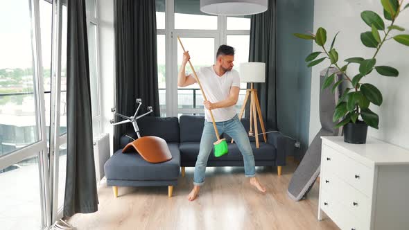 Man Cleaning the House and Having Fun Dancing with a Broom alt