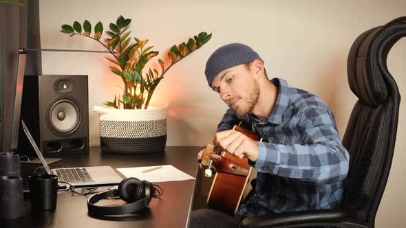 Musician tunes acoustic guitar. Tuning guitar alt