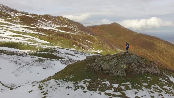 A trail runner runs up a snowy mountain alt