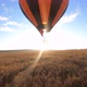 Orange Hot air ballon floating above sloping field at beautiful sunrise - VideoHive Item for Sale