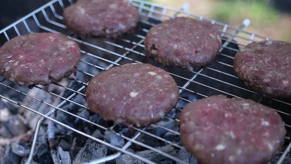Beef Burgers Cutlets are Roasting on the Charcoal Barbecue Grill alt