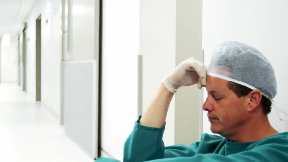 Sad surgeon sitting on the floor alt