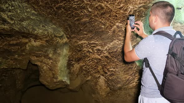 Tourist with a backpack in the cave. Speleology, cave, dungeon alt
