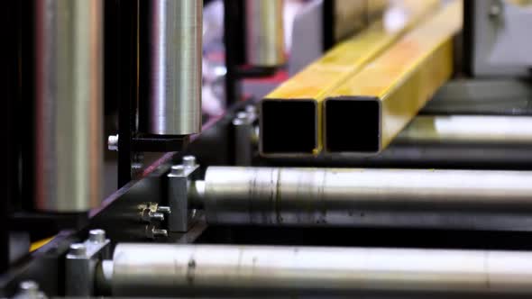 Metal Part Moves Along the Rollers of the Machine in Production