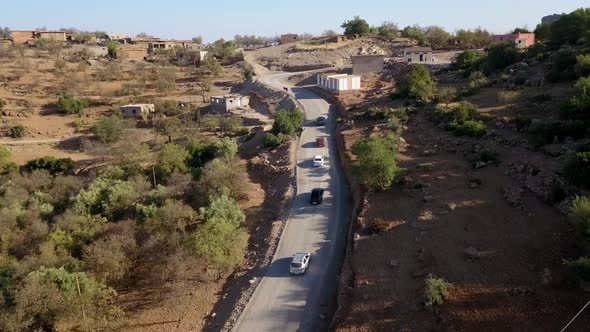 Drone view of the vehicles travelling through a mountainous road; winding roads in the mountains or alt
