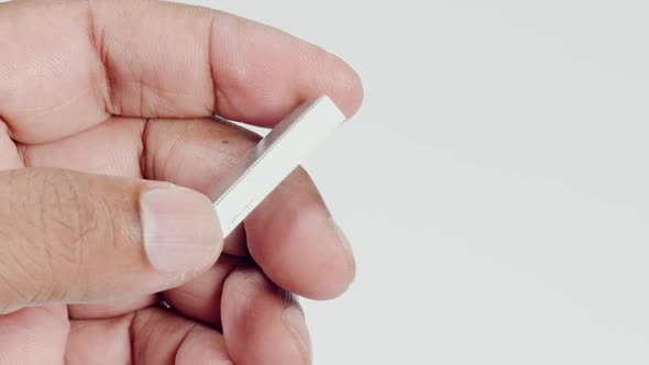 Fingers Holding Metal Staples alt