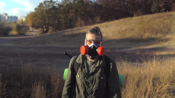Middleaged Gray Beard Man with Respirator Safety Goggles Climbs Mountain and Takes Baseball Bat From alt