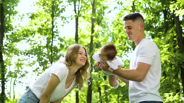 Happy Jewish family with little baby in summer garden alt