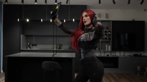 Portrait of Extravagant Travesty Woman in Sparkling Black Outfit Dancing Talking Streaming Online alt