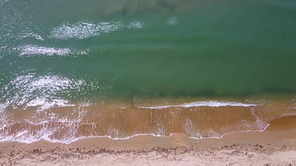 Small sea waves. Soft waves on a sandy beach. Seascape background alt