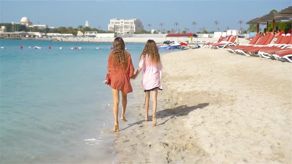 Little Happy Funny Girls Have a Lot of Fun at Tropical Beach Playing Together alt