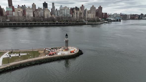 An aerial view of the Roosevelt Island lighthouse on a cloudy day. The camera truck left, pan right alt