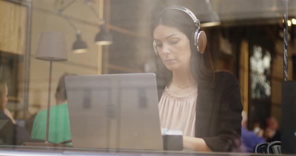 Back View of Caucasian Woman Working on a New Project in a Coffee Shop alt