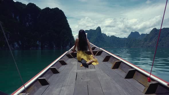 Cute Smiling Asian Sitting on a LongTail Boat in Cheow Lan Lake Thailand