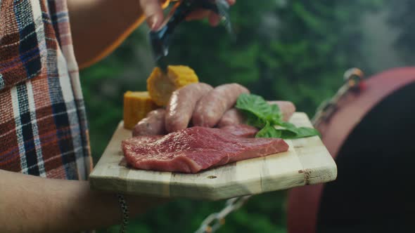 Juicy Steaks Sausage and Sweet Corn on a Plate Before Grilling