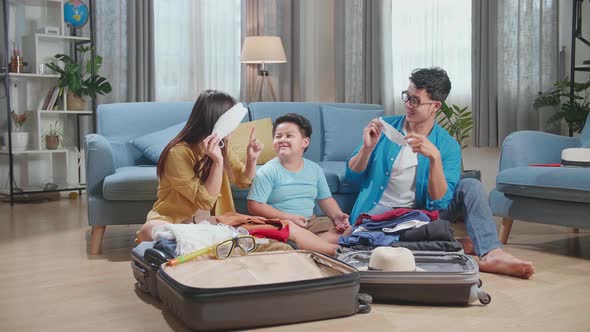 Family Packing Clothes And Protect Mask In A Suitcase For A New Journey. Luggage For Travel Holidays alt