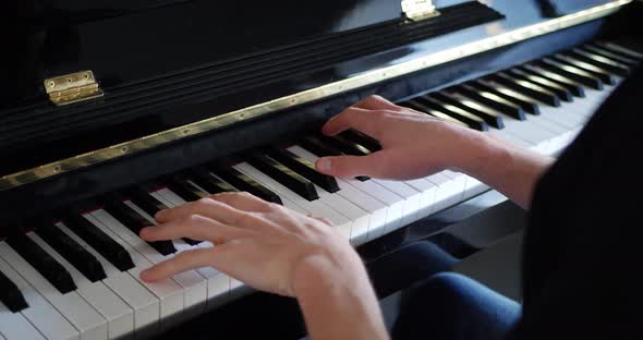 A pianist playing a piece of music on the keyboard of a piano instrument. alt