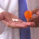Close up of African American doctor&#39;s hands holding pills and bottle - VideoHive Item for Sale