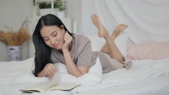 Pretty woman reading a book in bed