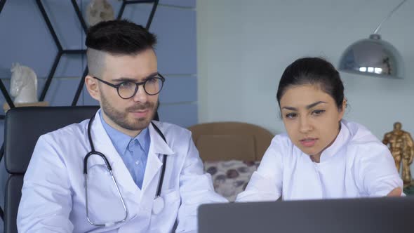 Close up of a Man and a Woman A Doctor and a Nurse Working at a Computer in the Hospital Office alt