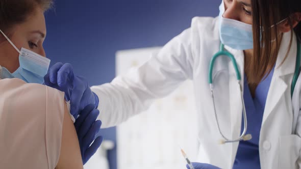 Video of doctor giving injection to a patient in clinic. Shot with RED helium camera in 8K. alt