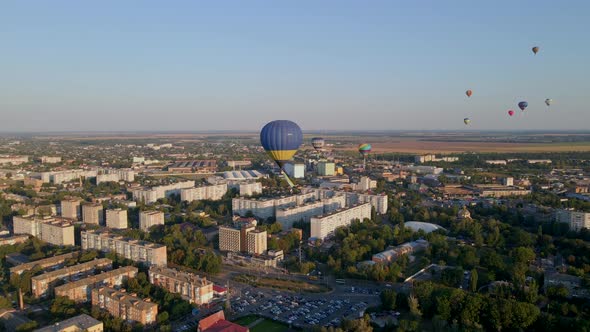 Aerial Drone View of Colorful Hot Air Balloon with Ukrainian Flag Flying Over Green Park in Small alt